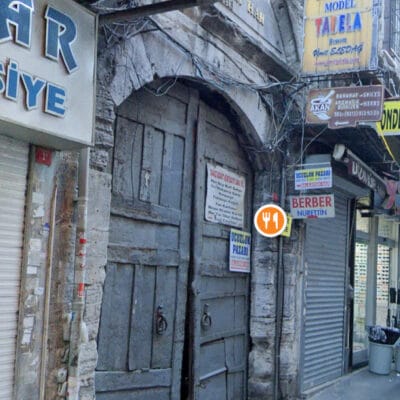 Eski taş kapı ve tarihi dükkan önü, Antalya'nın kalbinde geleneksel ve otantik atmosfer, turistik restoran ve mağazalar, kültürel doku, tarihi mekanlar, şehir merkezi, butik dükkanlar, antik yapıların mimarisi.